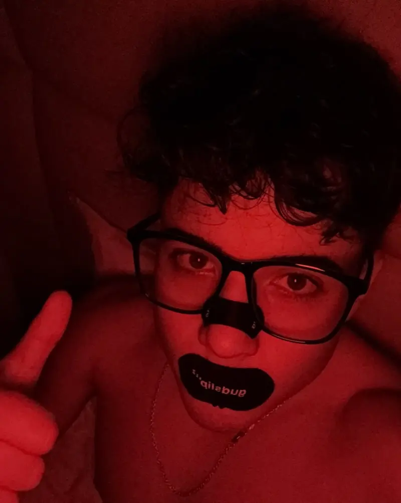 Iker con tiras en la nariz y la boca, bajo luz roja
